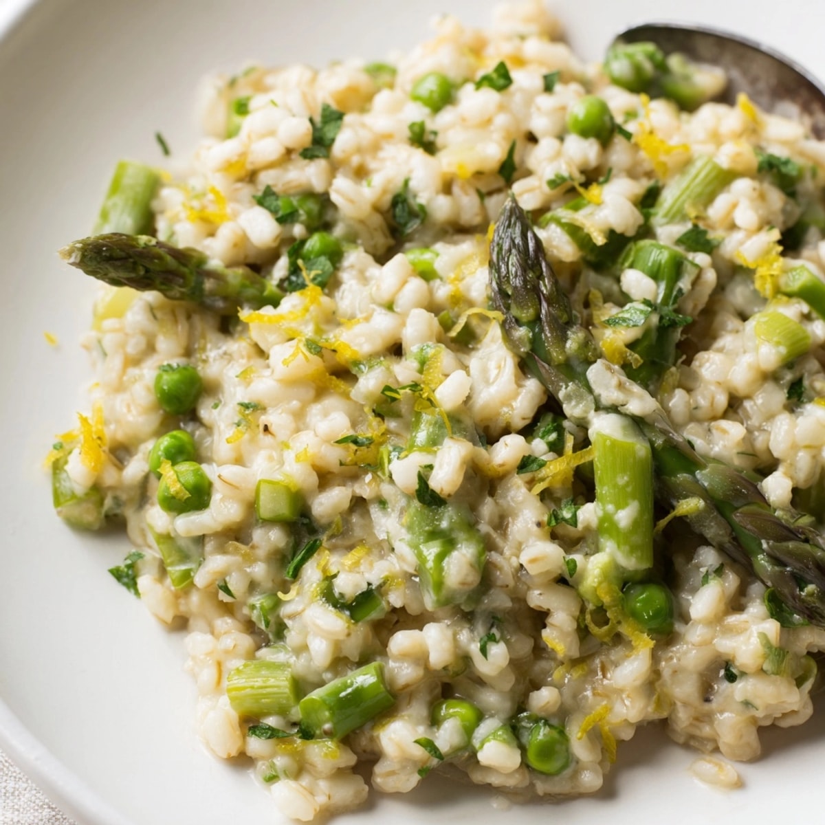 Aromatyczne jęczmienne risotto przepełnione soczystymi szparagami i słodkim groszkiem, idealne na wegetariański obiad.