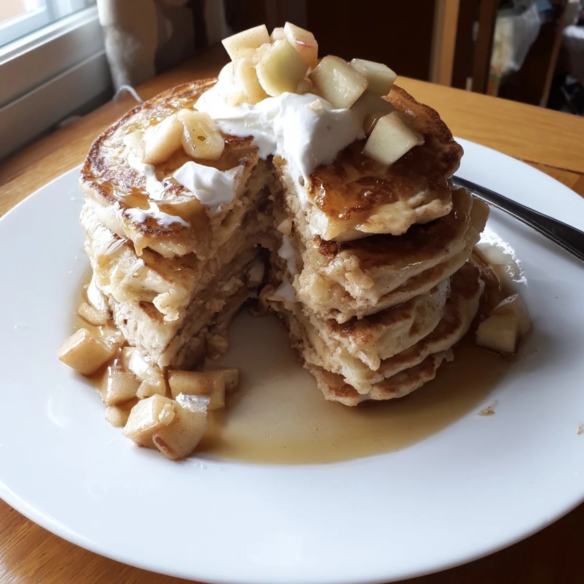 Golden brown cream soda apple pancakes, featuring fresh apple chunks and syrup.