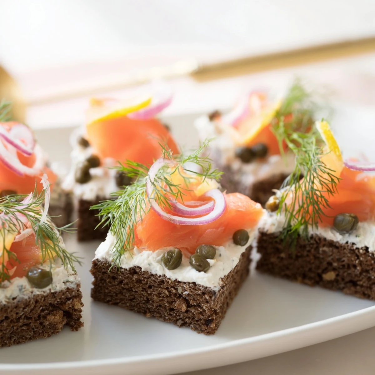 Eleganckie przekąski z wędzonym łososiem i chlebem żytnim, idealne na przyjęcia.  