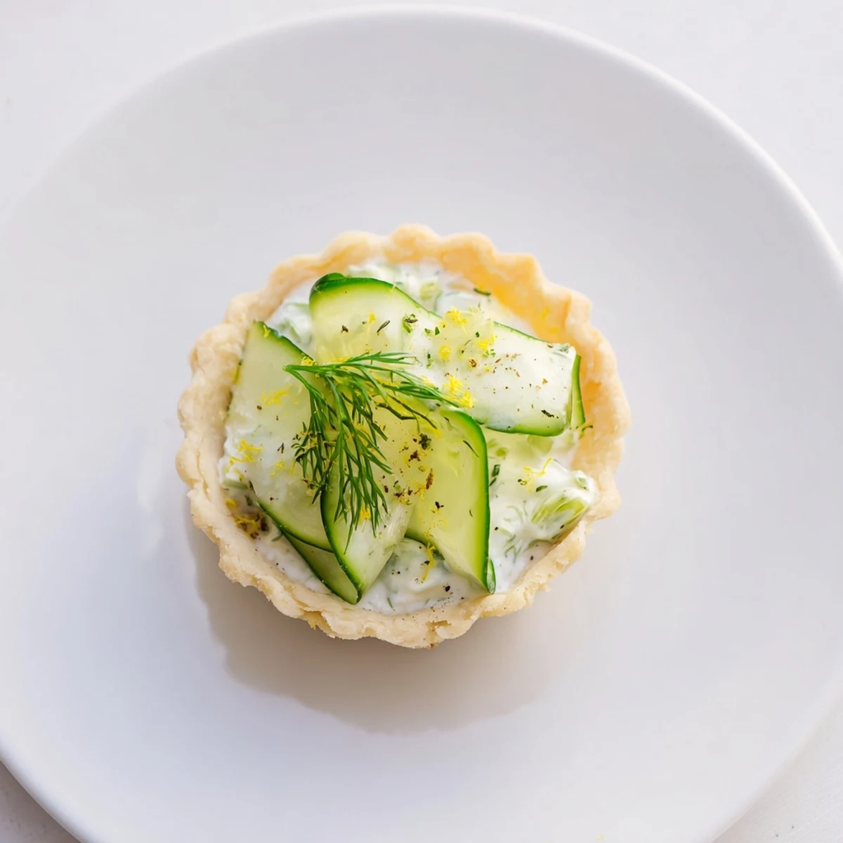 Delicate, flaky pastry shells filled with cool cucumber salad, these Simplified Mizeria Tartlets are a delicious treat.