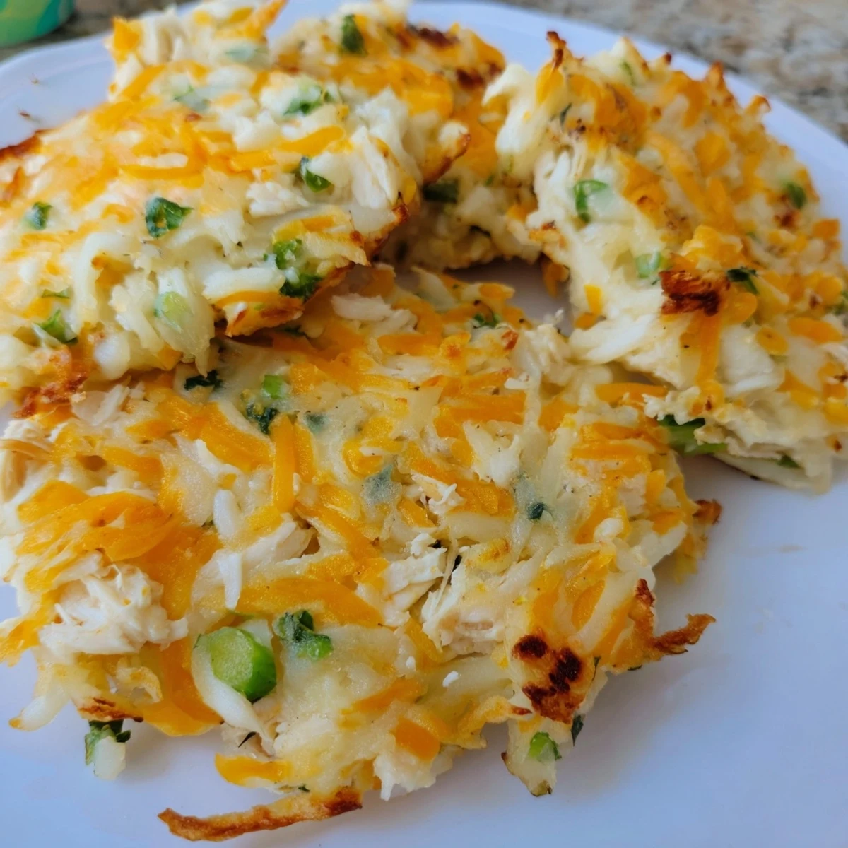 Złote i chrupiące placki z ziemniaków i kurczaka, gotowe do podania z dodatkami.