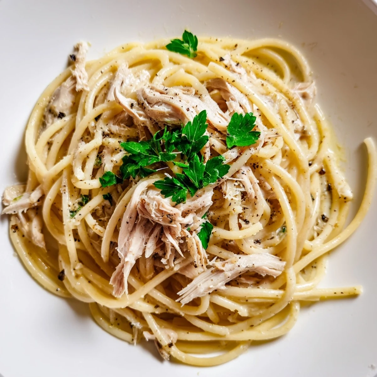 Zdjęcie przedstawia apetyczne, proste bucatini z czosnkowym masłem i delikatnym kurczakiem.