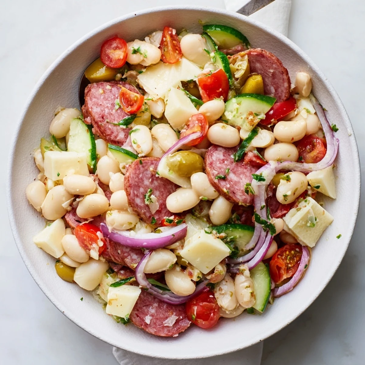 Zesty Italian Antipasto Bean Salad, a refreshing appetizer with vibrant tomatoes and savory salami.