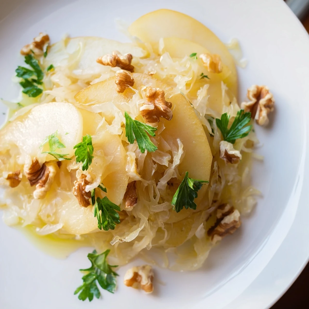 Sauteed golden apples and probiotic sauerkraut in a warm skillet, garnished with fresh parsley and walnuts, ready to serve as a tangy side salad.