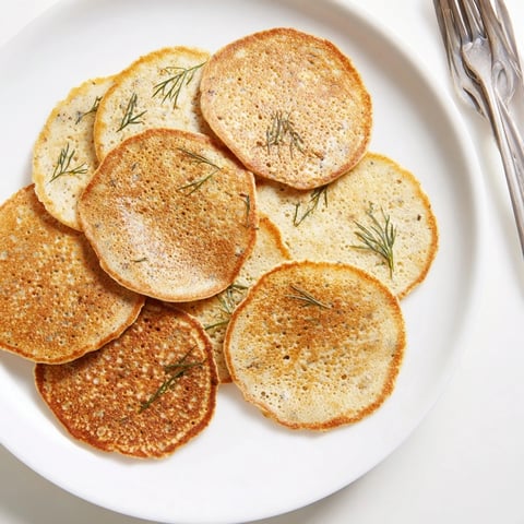 Delikatne bliny z gryki z świeżym koperkiem, idealne do podania ze śmietaną.  