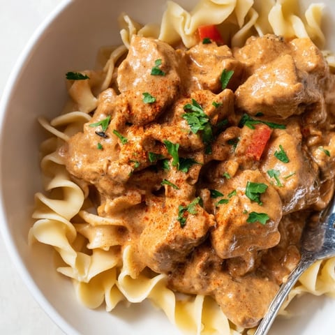 Aromatyczna miska makaronu z kurczakiem paprikash, pełna kremowego sosu.  