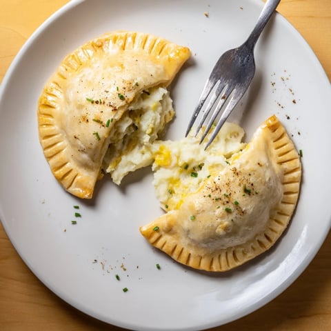 Złociste pierogi z serem, wypieczone na chrupiąco, idealne na przystawkę lub przekąskę.  