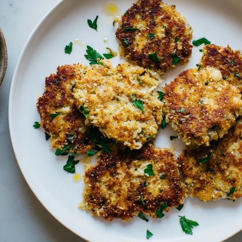 Złote, chrupiące placki z kapusty kiszonej serwowane z świeżą natką pietruszki.  