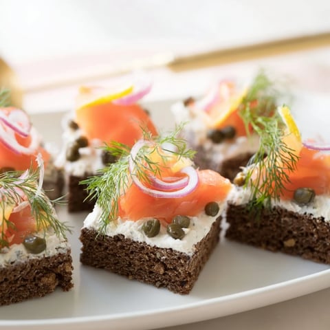 Eleganckie przekąski z wędzonym łososiem i chlebem żytnim, idealne na przyjęcia.  
