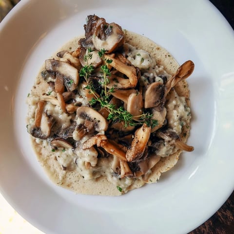 Zimowy ragout z grzybów z gryczanymi blinami, serwowany i pięknie polany obok blinów.