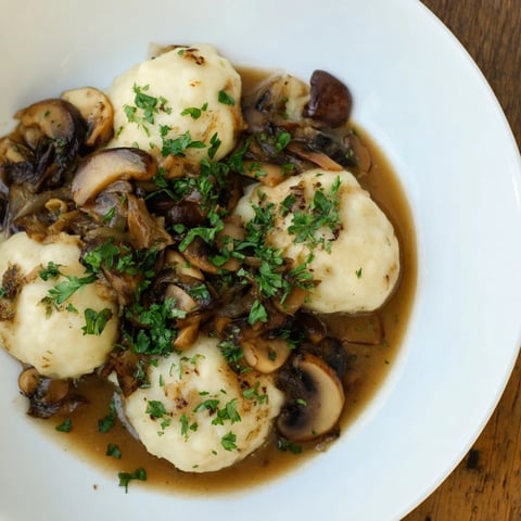 Chunky potato dumplings swimming in a rich mushroom sauce, a classic Polish comfort food.