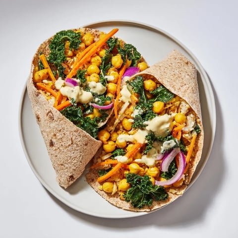 Apetyczne owinięcia z ciecierzycą i zimowymi warzywami, podawane z kremowym sosem.