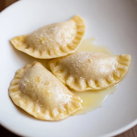 Melted butter glistens over golden-brown, freshly boiled 3-ingredient sweet pierogi ready to serve.