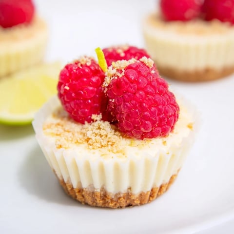 Golden, baked Quick Sernik Mini Cheesecake Cups glistening next to fresh berries for serving.
