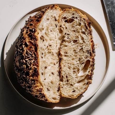 A warm loaf of Budget Polish Caraway Seed Bread, golden crust, ready to slice and eat.