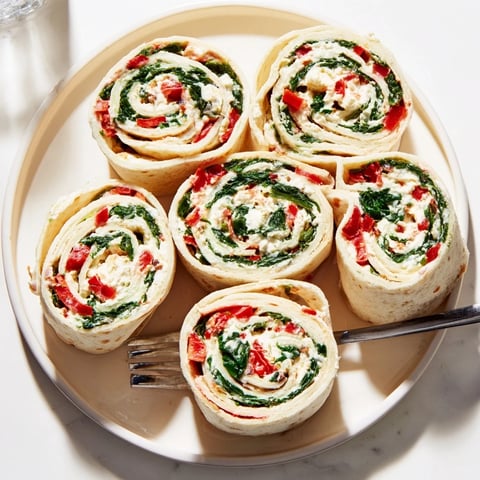 Colorful Christmas Scarf Tortilla Roll-Ups, perfect appetizer slices with red pepper and spinach filling.