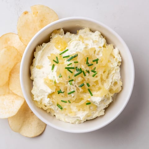 Crispy potato chips alongside creamy onion dip, a perfect party food for sharing.