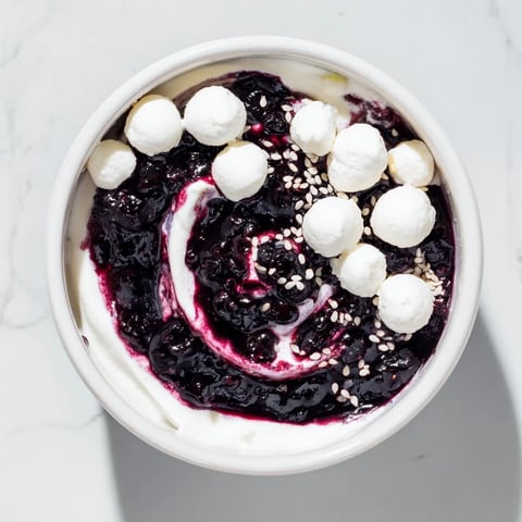 Beautiful Galaxy Spiral dessert swirls dark berry jam into creamy yogurt, ready to serve.