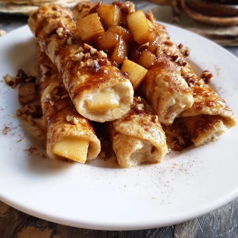 Kremowa miseczka owsianki z jabłecznikiem, z widocznymi kawałkami słodkich, smażonych jabłek.