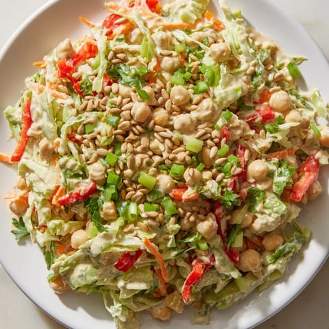 Delicious fiber-forward chickpea salad, vibrant with carrots, cabbage, and a creamy tahini dressing, ready to enjoy.