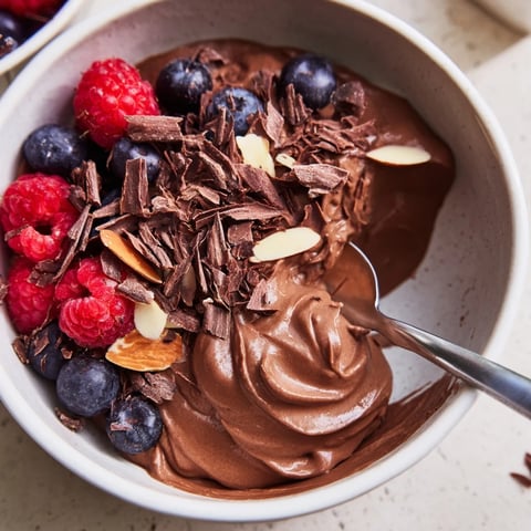 Silky smooth Chocolate Avocado Mousse, topped with fresh berries, a delightful vegan dessert.