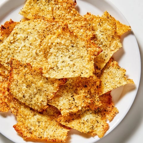 Złote, chrupiące chipsy z twarogu, aromatycznie przyprawione, idealne na szybką przekąskę.