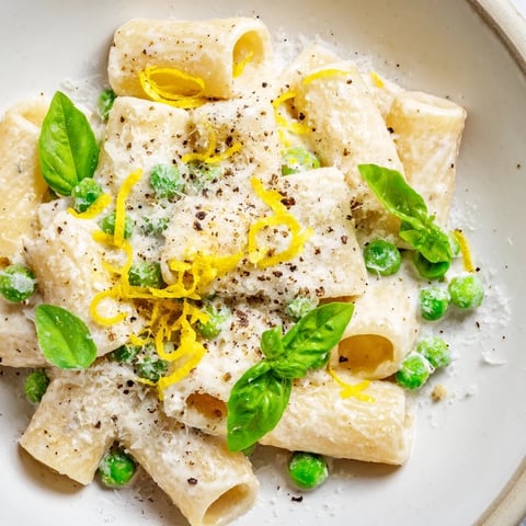 Creamy Pea & Lemon Ricotta Pasta, tossed with rigatoni, plated with fresh basil, ready to enjoy.