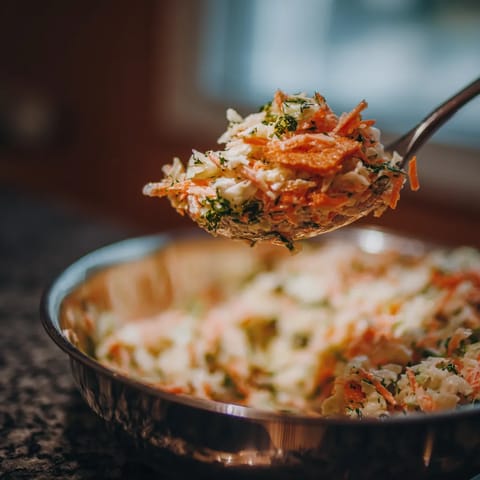 W słoneczny dzień, w domu, w kuchni, w misce zależy salatka jarzynowa.