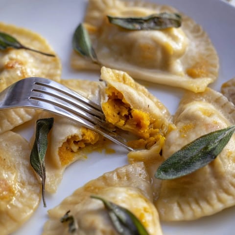 Homemade pierogi with autumn pumpkin filling: savory, cheesy autumnal comfort food, Eastern European heritage.