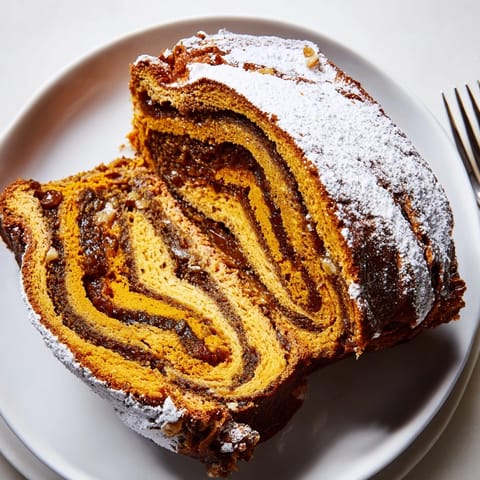 Świeżo upieczony Pumpkin Spice Makowiec, złocisty wierzch, gotowy do pokrojenia na świąteczny deser.