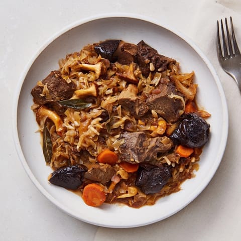 Kremowy, parujący Wild Mushroom Bigos w rustykalnym naczyniu - idealna jesienna potrawa dla smakoszy.