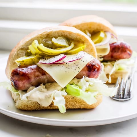 Smakowite mini kanapki z polską kiełbasą, chrupiącymi ogórkami i sosem na imprezy.  