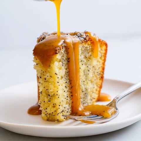 Soczyste ciasto makowe polać złotym karmelem, serwowane z bitą śmietaną.  