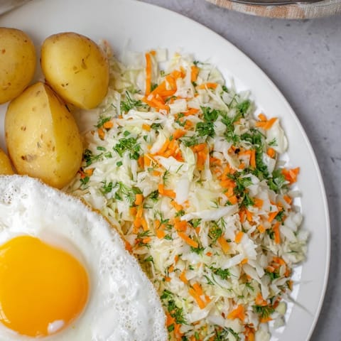 A hearty plate showcases Polish-style cabbage salad, offering flavors of apples and dill.