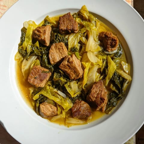 Aromatyczny gulasz z kapusty i wieprzowiny, podany z rustykalnym chlebem, pachnący obiadem.