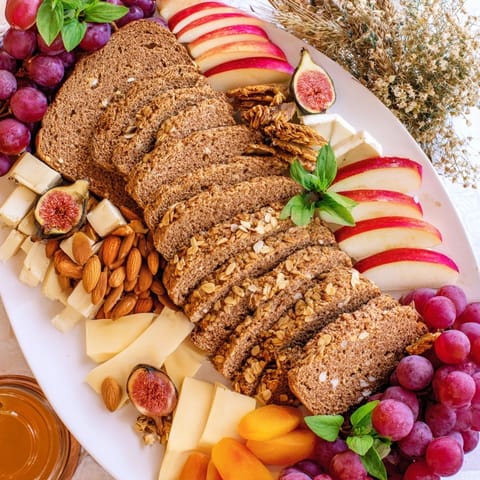 A rustic Harvest Scythe appetizer: fresh sliced apples and pears alongside crusty bread slices.