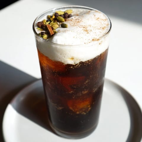 Enjoy the visually stunning Homemade Iced Chai with Cold Foam; a frothy, layered beverage.