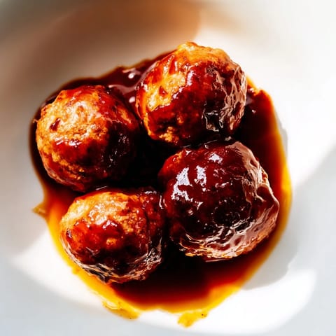 Grape Jelly and Chili Sauce Meatballs bubbling in a slow cooker, ready for a party buffet.