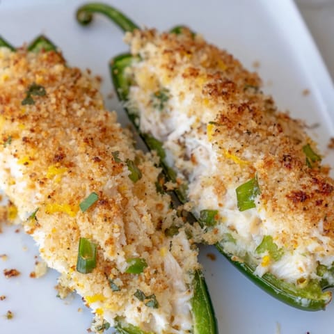 Soczyście nadziewane papryczki jalapeño z pikantnym nadzieniem z kraba, serem i ziołami, pieczone do złotego koloru jako idealna przekąska.  