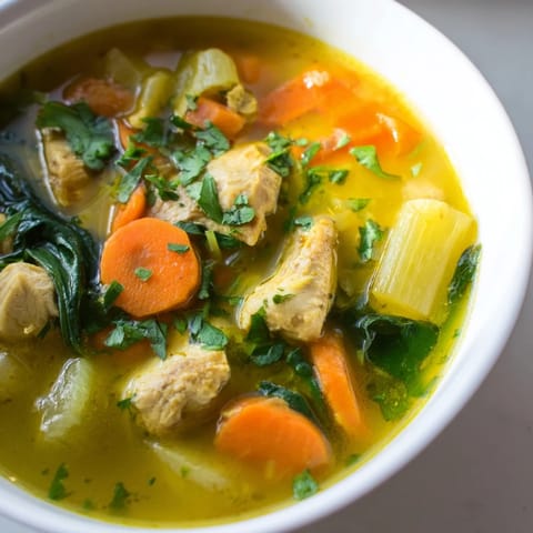 Gęsta, aromatyczna zupa z kurczaka z kurkumą i szpinakiem, posypana kolendrą, idealna na chłodne dni.  