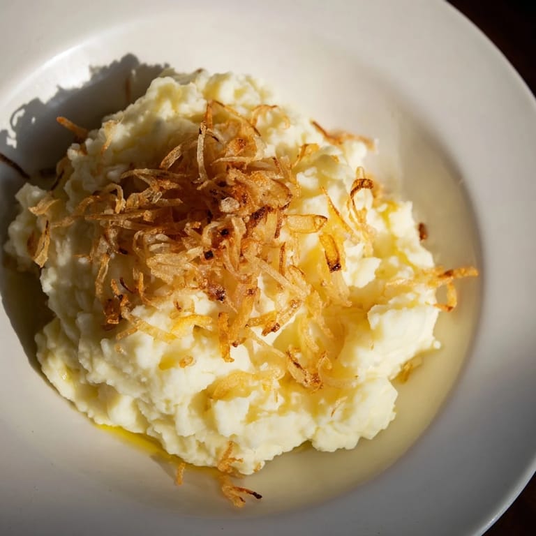 Fluffy Garlic Mashed Potatoes, a comforting side topped with crispy fried onions for a flavorful treat.