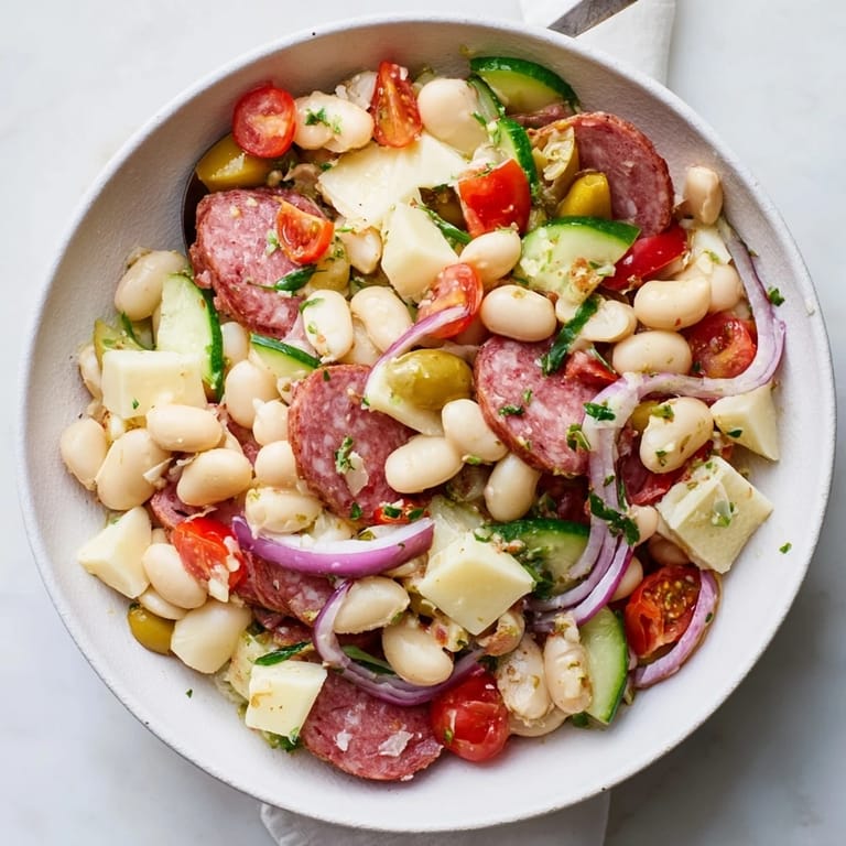Zesty Italian Antipasto Bean Salad, a refreshing appetizer with vibrant tomatoes and savory salami.