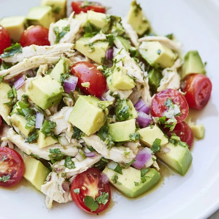 Close-up of a refreshing avocado chicken salad, ready to eat with vibrant herbs.