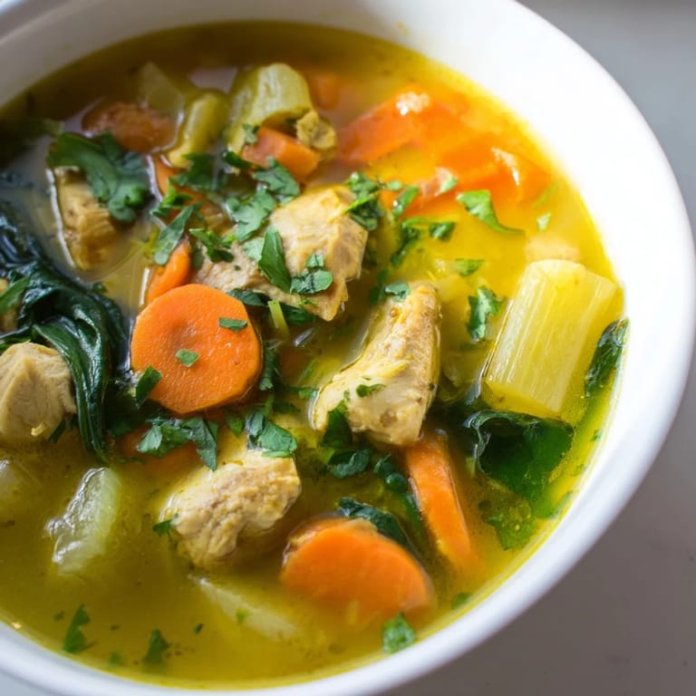 Gęsta, aromatyczna zupa z kurczaka z kurkumą i szpinakiem, posypana kolendrą, idealna na chłodne dni.  