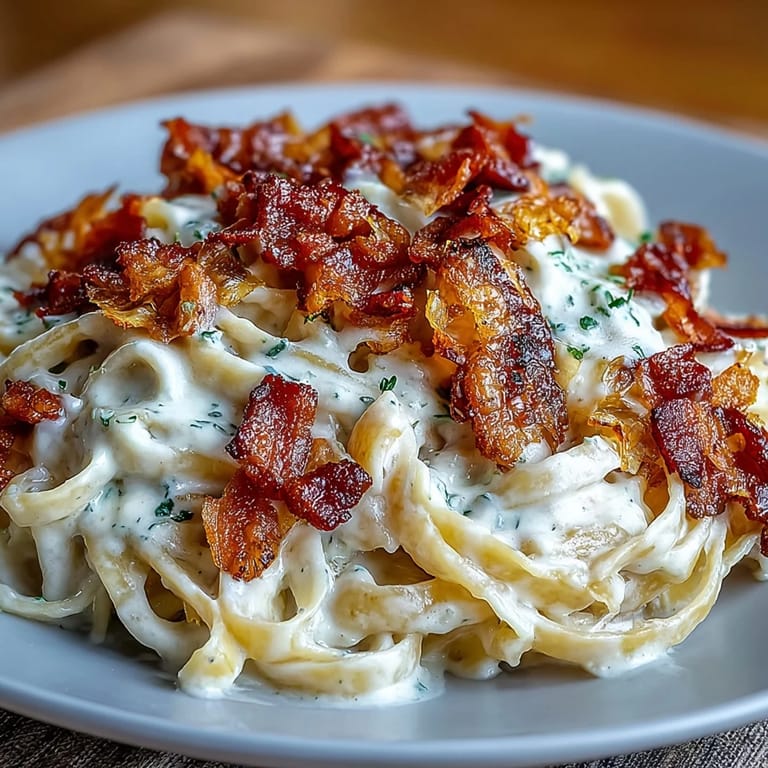 Złocisty makaron Alfredo z chrupiącym boczkiem, kapustą, podany z parmezanem.